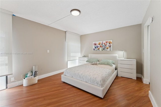bedroom with light wood-type flooring and baseboards