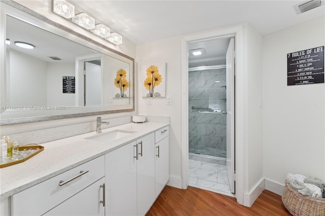 bathroom with visible vents, a shower stall, vanity, baseboards, and marble finish floor