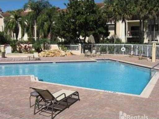 11229 W Atlantic Blvd Unit 204, Coral Springs, FL 33071 - community pool featuring a patio and fence