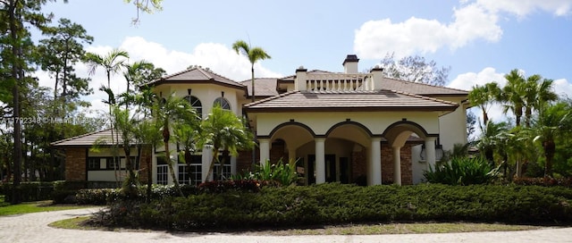 rear view of house with a chimney, stucco siding, and brick siding