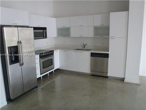 234 NE 3rd St Unit 1208, Miami, FL 33132 - kitchen with a sink, concrete flooring, white cabinets, and stainless steel appliances