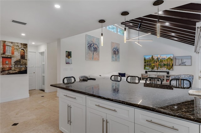 kitchen featuring white cabinetry, visible vents, pendant lighting, and dark stone counters