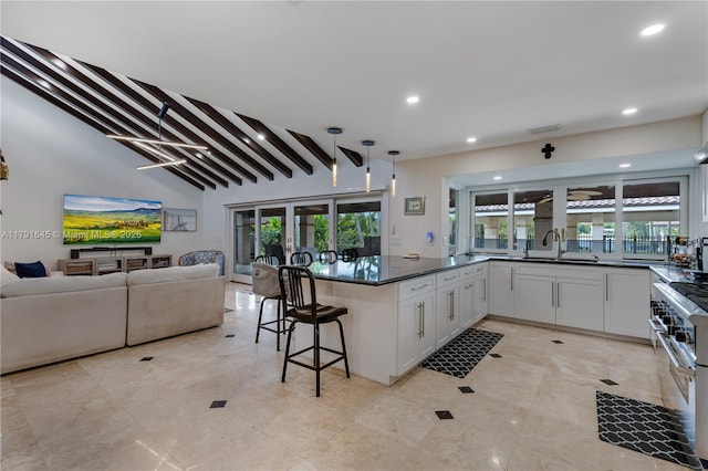 kitchen with high end range, recessed lighting, open floor plan, and white cabinets
