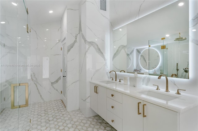 bathroom featuring double vanity, a marble finish shower, and a sink