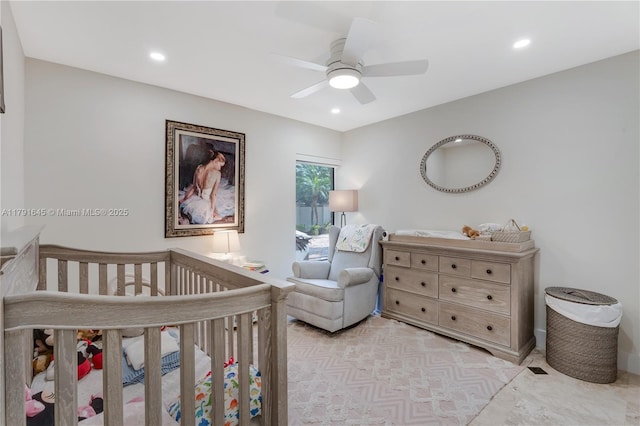 bedroom featuring ceiling fan, recessed lighting, and a crib
