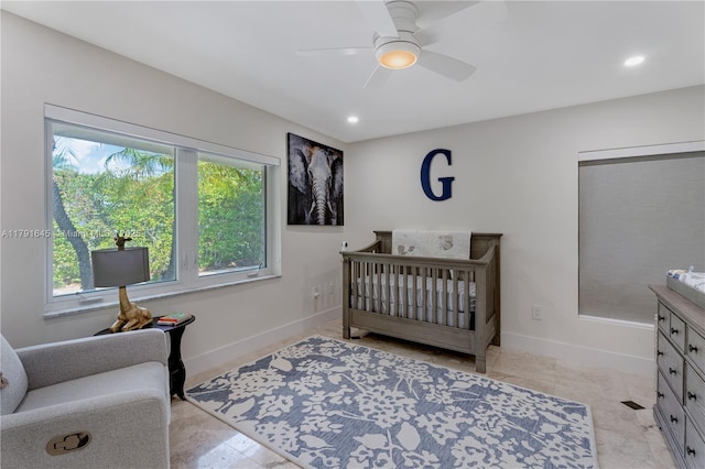 bedroom with recessed lighting, ceiling fan, a nursery area, and baseboards