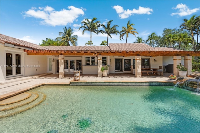 back of property with french doors, a patio area, a ceiling fan, and an outdoor pool