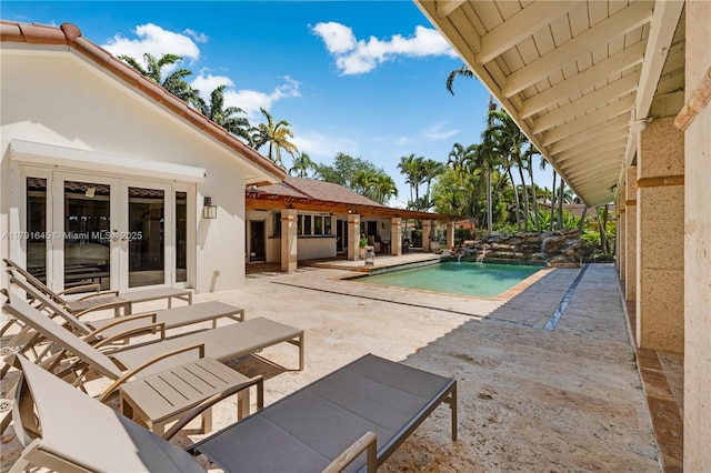 outdoor pool with a patio and french doors