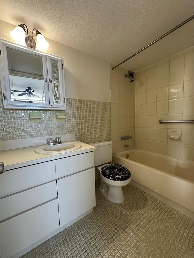 full bathroom featuring tile walls, vanity, toilet, tub / shower combination, and a textured ceiling