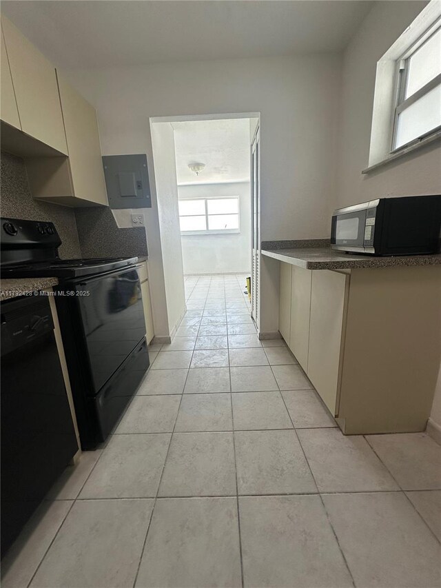 1750 James Ave Unit 10A, Miami Beach, FL 33139 - kitchen featuring black appliances, electric panel, light tile patterned floors, backsplash, and dark countertops