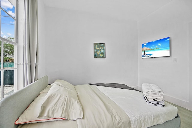 bedroom with wood finished floors and baseboards