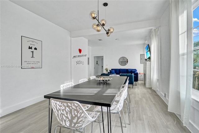dining space featuring an inviting chandelier, light wood-type flooring, and baseboards