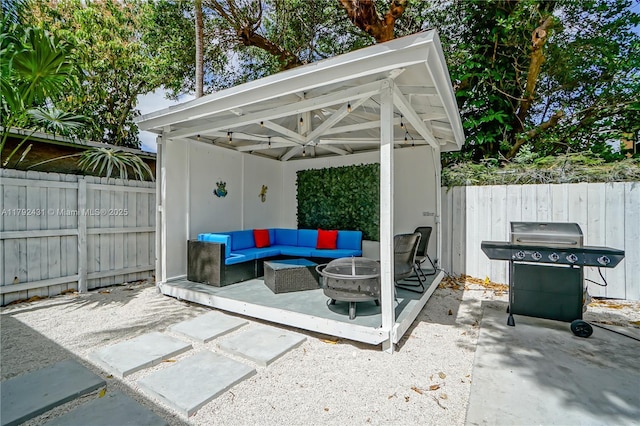 view of patio / terrace with area for grilling, a fenced backyard, and an outdoor living space with a fire pit
