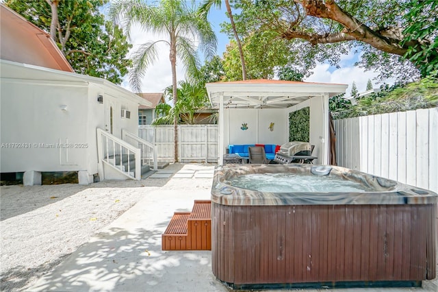 view of patio / terrace featuring a gazebo, a fenced backyard, and a hot tub