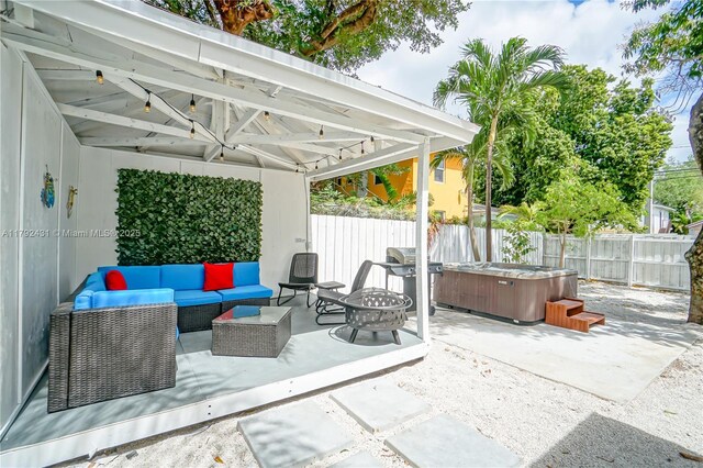 view of patio / terrace featuring a fenced backyard, grilling area, a hot tub, and an outdoor living space with a fire pit
