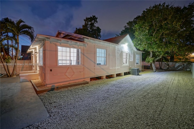 view of side of property with fence and central AC