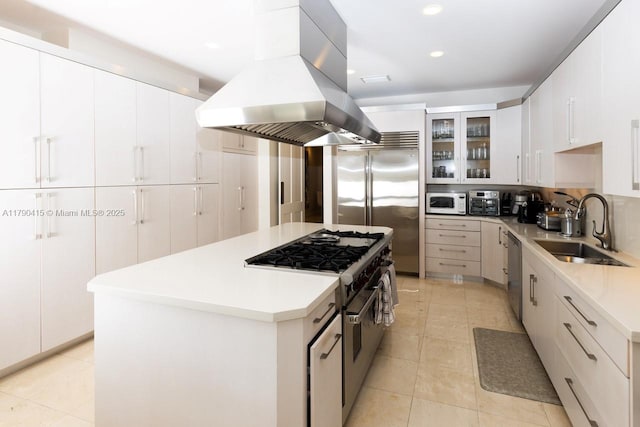 kitchen with a sink, island range hood, premium appliances, light countertops, and a center island
