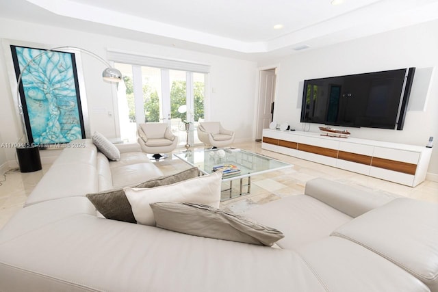living room with recessed lighting, a raised ceiling, and baseboards