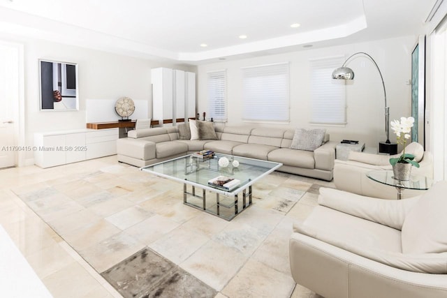 living room with recessed lighting, tile patterned flooring, and a tray ceiling