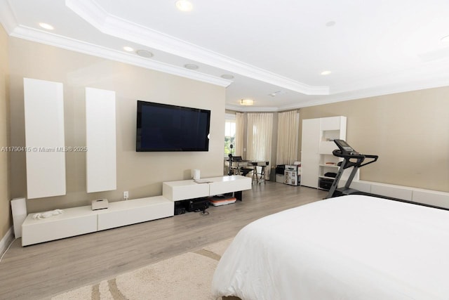 bedroom featuring recessed lighting, ornamental molding, wood finished floors, and a raised ceiling