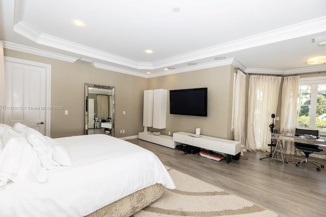 bedroom featuring ornamental molding, recessed lighting, wood finished floors, and a tray ceiling