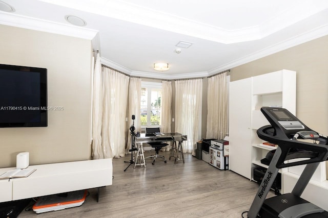 workout area with crown molding, visible vents, and light wood-style flooring