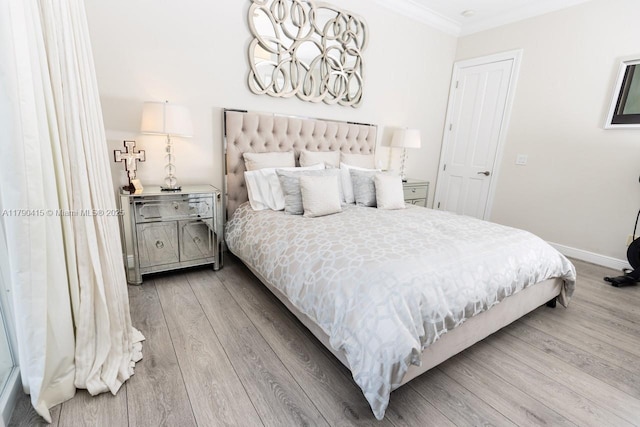 bedroom with an inviting chandelier, wood finished floors, ornamental molding, and baseboards
