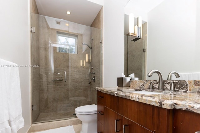 bathroom with a stall shower, toilet, and vanity