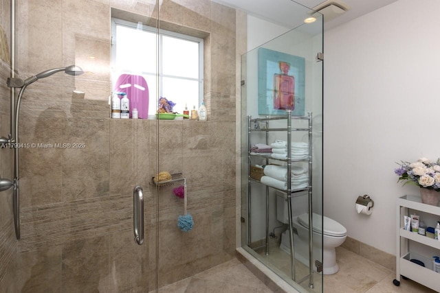 full bathroom featuring toilet, a shower stall, and tile patterned floors