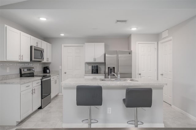 1808 NE 7th Ave, Cape Coral, FL 33909 - kitchen featuring a kitchen breakfast bar, a sink, appliances with stainless steel finishes, visible vents, and a kitchen island with sink