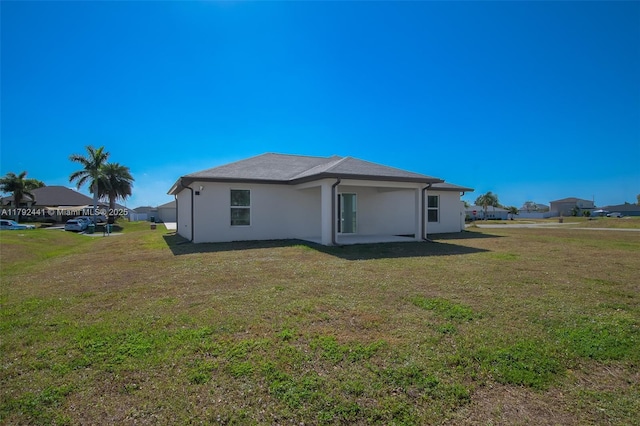 1808 NE 7th Ave, Cape Coral, FL 33909 - back of house with stucco siding and a lawn