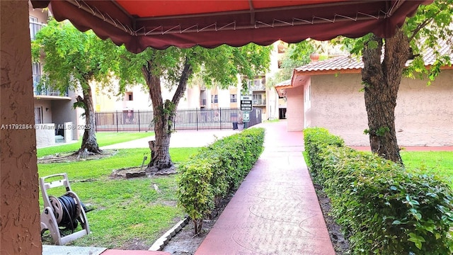 view of property's community featuring fence and a lawn