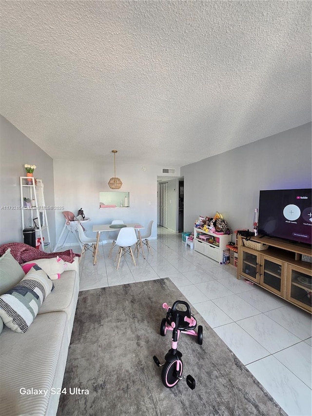 tiled living area with visible vents and a textured ceiling