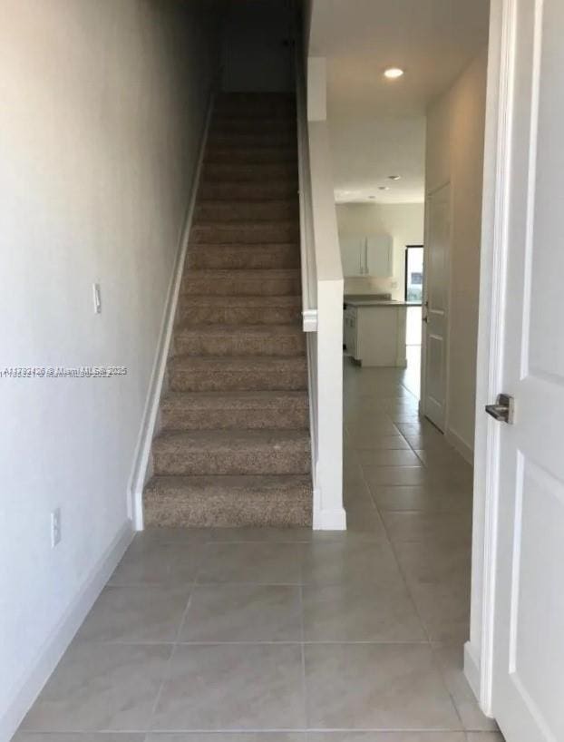 stairway with tile patterned floors, recessed lighting, and baseboards