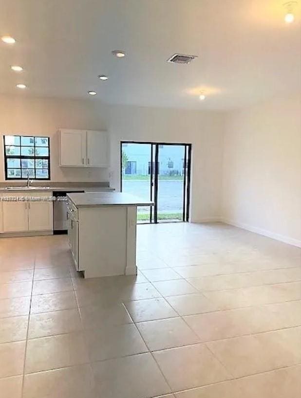 kitchen featuring recessed lighting, light tile patterned flooring, light countertops, and a sink