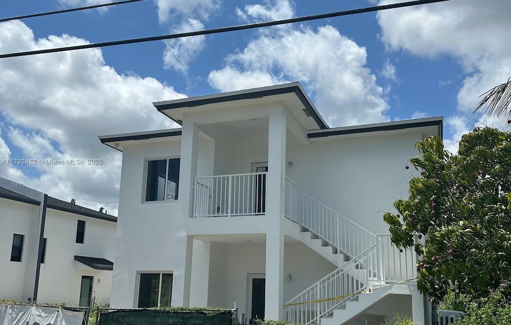 view of home's exterior featuring stairs and stucco siding