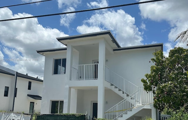 view of home's exterior featuring stairs and stucco siding