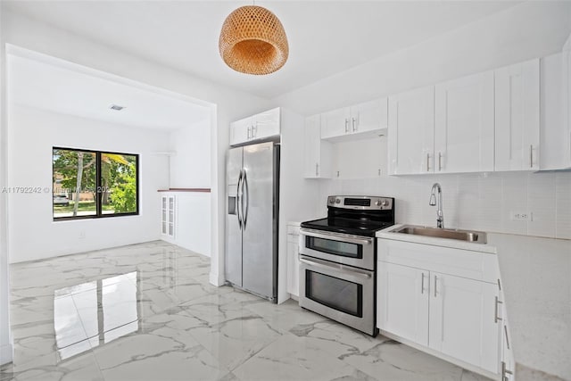 1683 NE 168th St, North Miami Beach, FL 33162 - kitchen featuring white cabinets, a sink, appliances with stainless steel finishes, marble finish floor, and backsplash