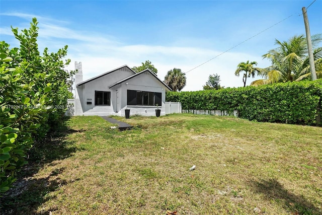 1683 NE 168th St, North Miami Beach, FL 33162 - rear view of house featuring stucco siding and a yard