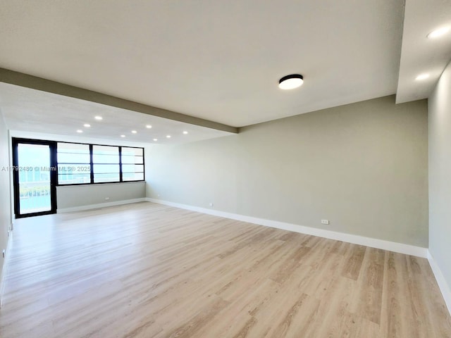 empty room featuring recessed lighting, light wood finished floors, and baseboards
