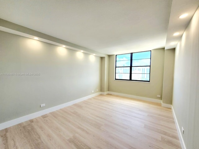 unfurnished room featuring recessed lighting, light wood-style flooring, and baseboards
