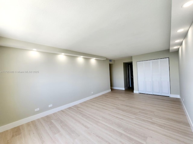 unfurnished bedroom with recessed lighting, a closet, baseboards, and light wood-style floors