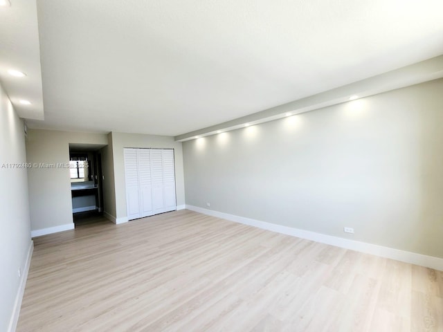 spare room with recessed lighting, baseboards, and light wood-style floors