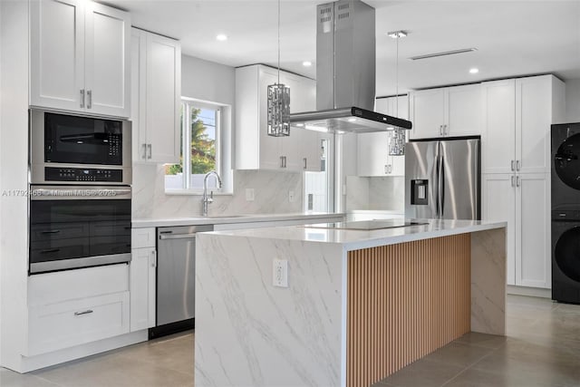 kitchen with a kitchen island, island range hood, stacked washer / drying machine, a sink, and black appliances