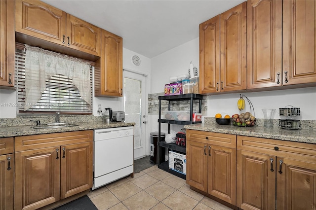 6550 SW 28th St, Miramar, FL 33023 - kitchen with light stone counters, light tile patterned floors, a sink, white dishwasher, and brown cabinetry