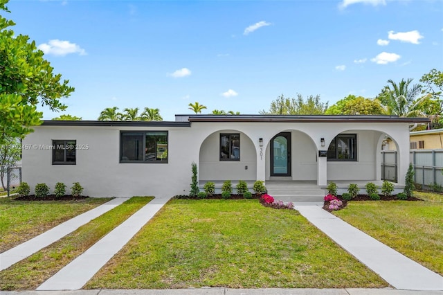 ranch-style house featuring stucco siding, a porch, and a front yard