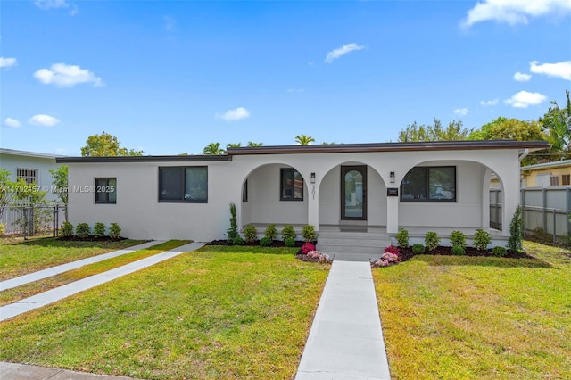 ranch-style home featuring fence, stucco siding, a porch, and a front lawn