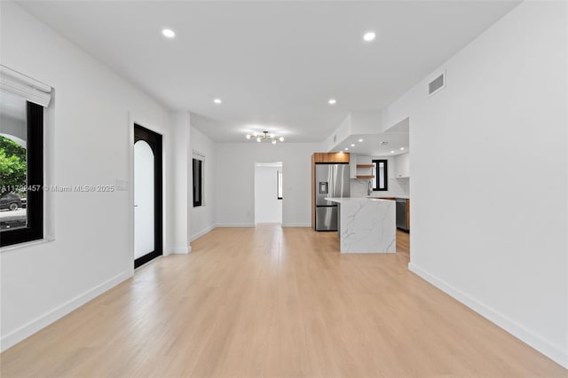 unfurnished living room with visible vents, recessed lighting, light wood-style floors, and baseboards
