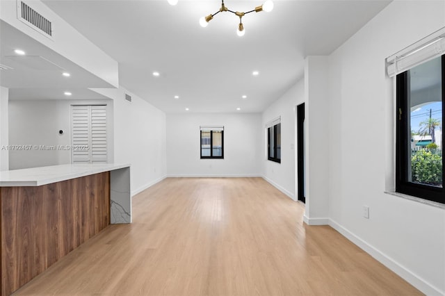spare room featuring visible vents, baseboards, an inviting chandelier, recessed lighting, and light wood-style flooring