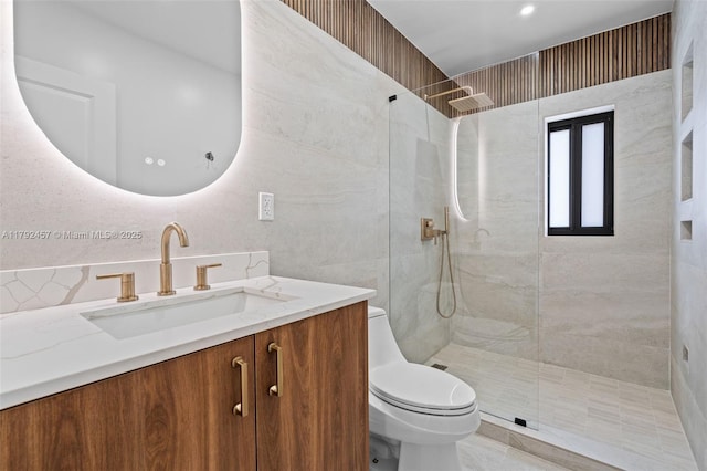 bathroom featuring vanity, a tile shower, and toilet